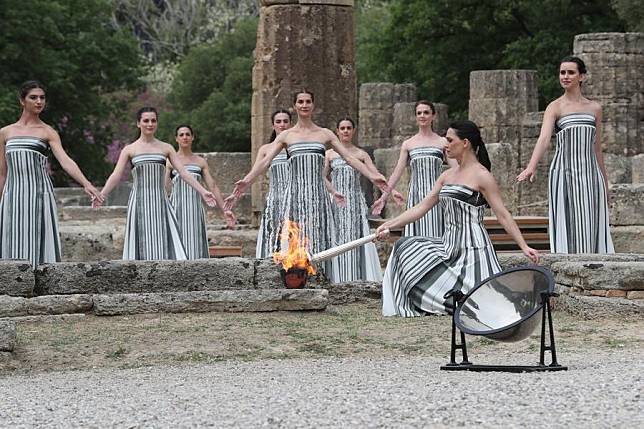 Greek actress Mary Mina, playing the role of an ancient Greek High Priestess, lights the torch during the Olympic flame lighting ceremony for the Paris 2024 Olympic Games, in Ancient Olympia, Greece, on April 16, 2024. (Xinhua/Li Jing)