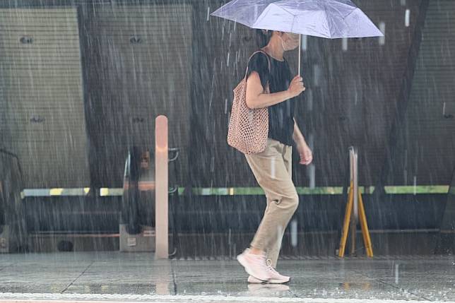 受杜蘇芮颱風影響，街道上民眾撑傘擋雨勢。（柯承惠攝）