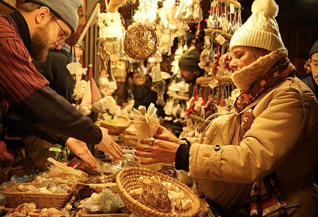 A woman chooses holiday decorations at a Christmas market at the Old Town Square in Prague, the Czech Republic, on Nov. 30, 2024. (Photo by Dana Kesnerova/Xinhua)