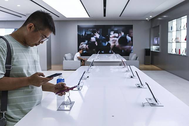 A customer examines a smartphone on display at the Oppo store inside the Consumer Electronics Exchange/Exhibition Centre in Shenzhen’s Futian district. Photo: Roy Issa