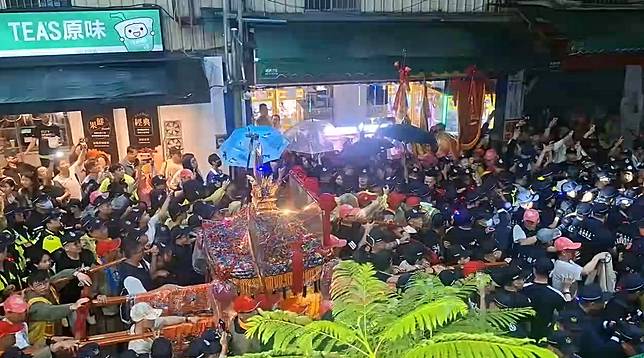 大甲媽祖鑾轎回鑾，24日晚間準備前往天后宮駐駕前，爆發一群黑衣人試圖搶扶娘傘，警方強制推開人群，化解衝突。Threads網友授權