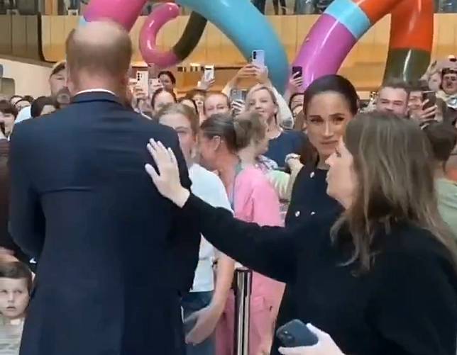 幕僚長拍了拍哈利王子的肩膀，一旁的梅根收起笑容瞪著她，表情明顯不悅。（翻攝X@that_1）