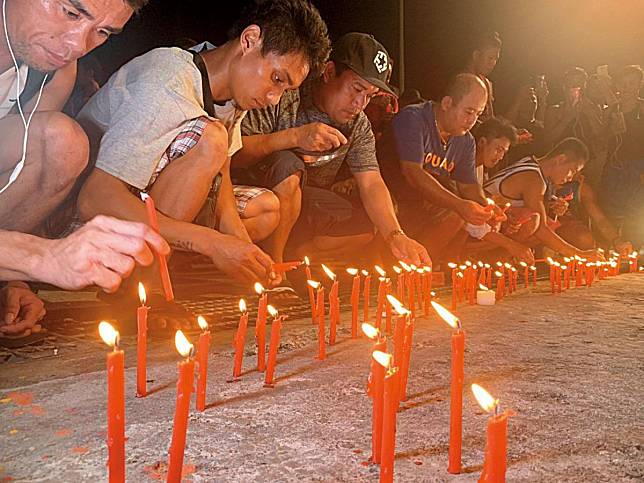 南方澳外籍漁工為死亡的6名同胞點蠟燭祈禱。（讀者提供）
