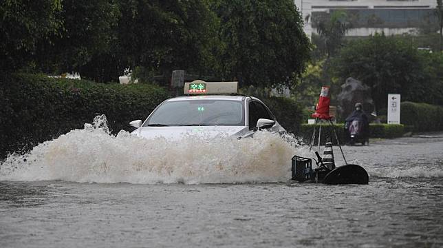 A taxi moves through a waterlogged road in Sanya, south China's Hainan Province, Oct. 28, 2024. (Xinhua/Zhao Yingquan)