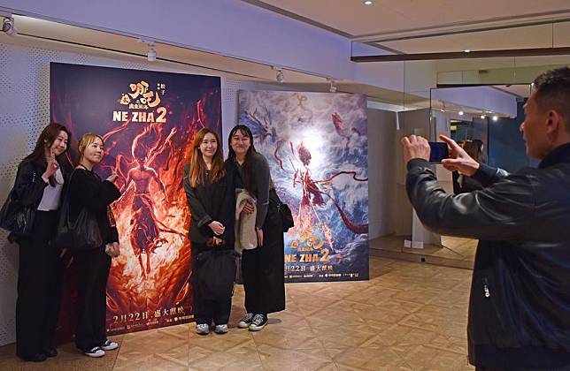 People pose for photos in front of the poster of the Chinese animated feature &ldquo;Ne Zha 2&rdquo; at a cinema in Hong Kong, south China, Feb. 18, 2025. (Xinhua/Chen Duo)