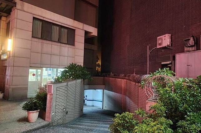 台中市北區英才路一處社區飄屍臭，居民在圍牆與大樓之間的縫隙赫見躺著一具女屍，嚇得趕緊報案。（記者陳金龍翻攝）
