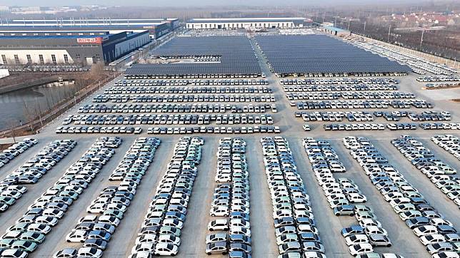 An aerial drone photo taken on Jan. 12, 2024 shows new energy vehicles ready for shipment at a factory in Rizhao, east China's Shandong Province, Jan. 12, 2024. (Xinhua/Guo Xulei)