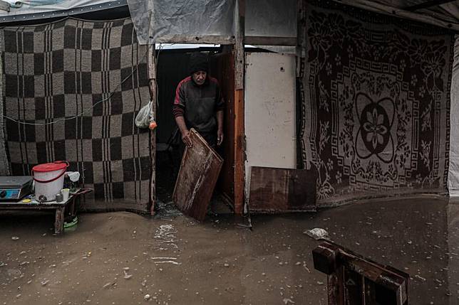 A man is seen inside a flooded tent after heavy rain in the Mawasi area of Khan Younis, southern Gaza Strip, on Nov. 25, 2024. UN humanitarians said on Monday they and their partners have been evaluating flood damage in a response to multiple sites for displaced Gazans hit by heavy weekend rainfall. (Photo by Rizek Abdeljawad/Xinhua)