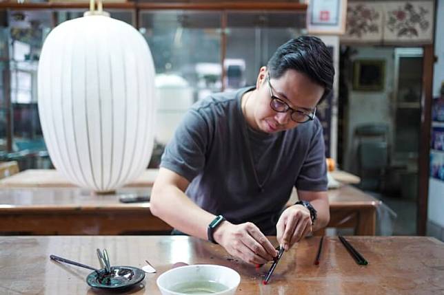 賴信佑示範研磨漆筷的細緻動作。