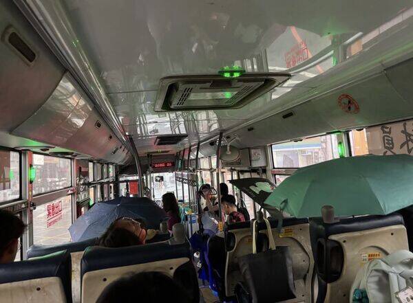 員林客運車頂直漏水，乘客車內撐傘坐車。(民眾提供)