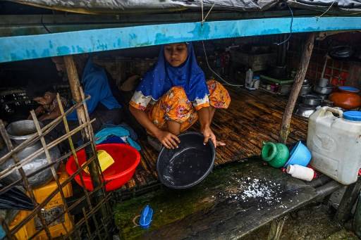 หญิงชาวมุสลิมกำลังทำครัวในค่ายที่พักในเมืองเจ้าผิว ในรัฐยะไข่ โดยมีทหารเมียนมาควบคุมเช่นนี้มาหลายปีแล้ว Ye Aung THU / AFP
