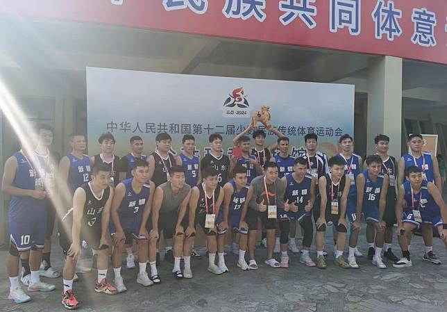 Players of Shandong and Xinjiang take a group photo after their men's pearl ball group match at China's 12th National Traditional Games of Ethnic Minorities in Sanya, south China's Hainan Province. (Handout via Xinhua)