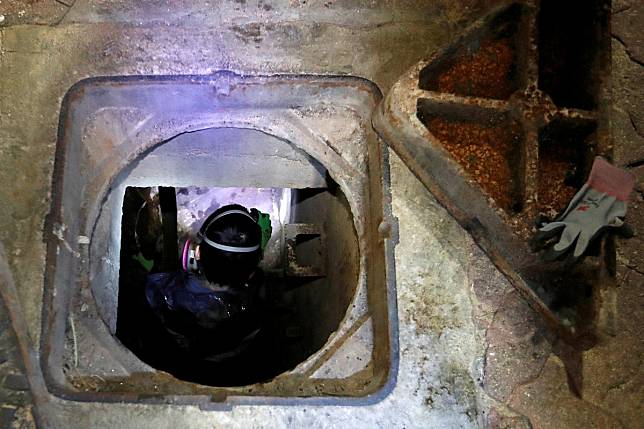 A protester tries to escape through a sewage tunnel inside Polytechnic University. Photo: Reuters