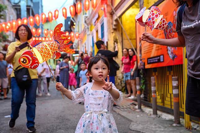 People enjoy themselves during a parade with fish-shaped lanterns in Kuala Lumpur, Malaysia, Jan. 18, 2025. (Xinhua/Chong Voon Chung)