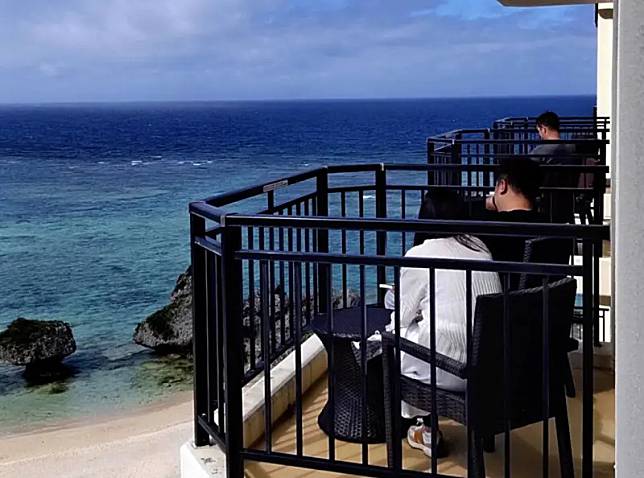 ▲在海嘯警報發布之後，人正在沖繩縣的觀光客待在飯店，不安地望向大海。（圖／美聯社／達志影像）