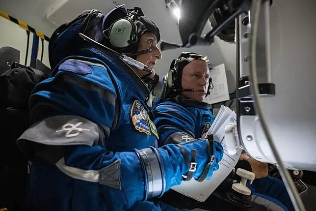 NASA太空人魏勒摩爾（Butch Wilmore）和威廉斯（Suni Williams）於2022年11月3日在NASA約翰遜太空中心（Johnson Space Center）的波音星際飛機模擬器中，進行穿著太空服的緊急情況模擬操作。（翻攝NASA/Robert Markowitz）