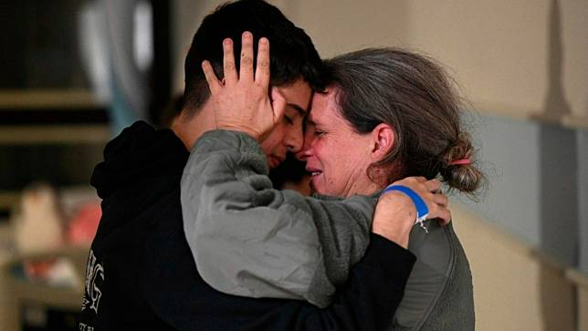 一名獲釋的以色列人質與親友團聚喜極而泣。美聯社