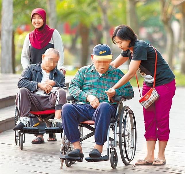 引進東南亞移工利潤高，但政治人脈顯然是關鍵。圖為公園內陪伴老者的印尼籍看護工。（本報資料照片）