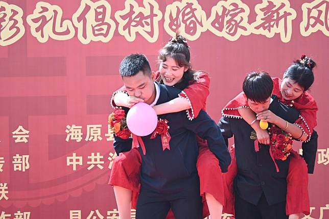 Wang Lan (2nd L) and her husband (1st L) play games at a group wedding ceremony in Haiyuan County of Zhongwei City, northwest China's Ningxia Hui Autonomous Region on May 20, 2024. (Xinhua)