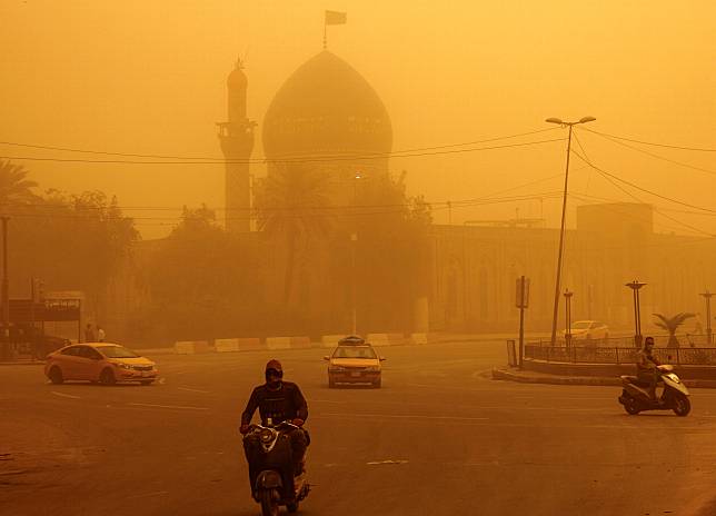 伊拉克首都巴格達（Baghdad）被巨大的塵雲包圍，平常交通壅塞的街道變得冷清，沉浸在一片怪異的橘色天光中。（路透社）