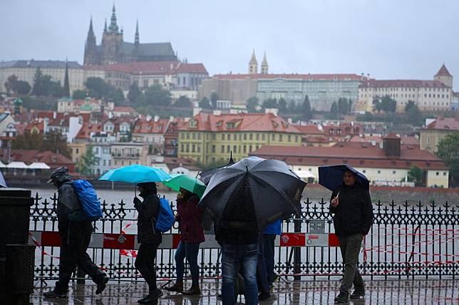 People walk in the rain near the Vltava River in Prague, the Czech Republic, on Sept. 13, 2024. (Photo by Dana Kesnerova/Xinhua)