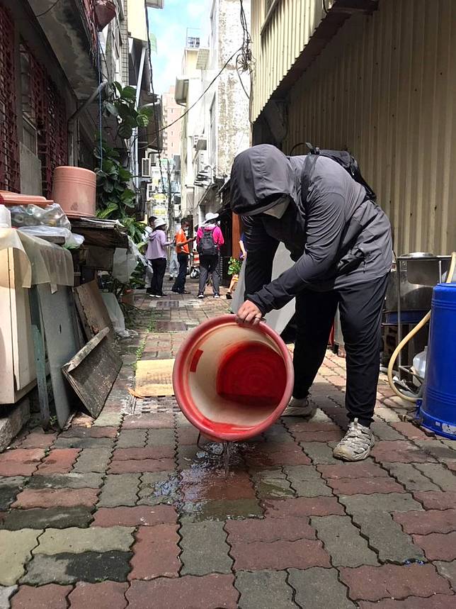 防治人員將陽性積水容器倒在馬路上，徹底殺死孑孓。 （南市衛生局提供）