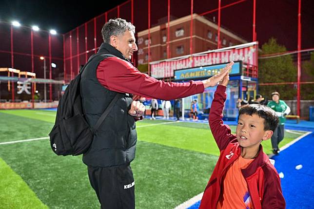 Serbian coach Aleksandar Pantic (L) high-fives with a young football player after a training session at Tianjin Football Association Youth Training Center in north China's Tianjin Municipality, on April 23, 2024. (Xinhua/Sun Fanyue)