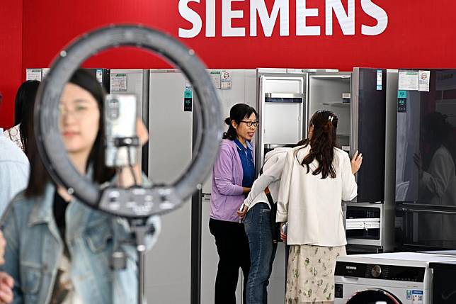 Consumers learn about relevant policies during a consumer goods trade-in event in Qingdao City, east China's Shandong Province, May 17, 2024. (Xinhua/Li Ziheng)