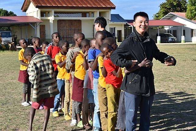 中華大學國際志工團師生搭機飛越上萬公里，到非洲莫三比克援助貧病孤兒。志工們手把手教導院區孩童寫注音，一一檢查學習情況。(圖由中華大學提供)