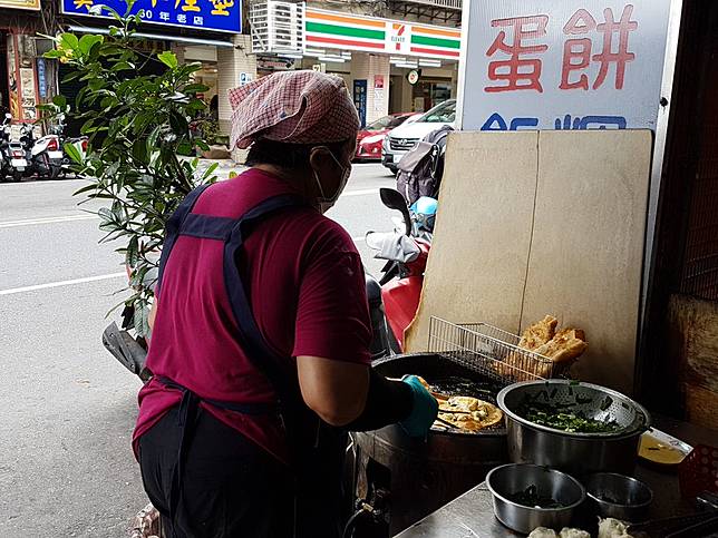 ▲動作熟練的工作阿姨以半煎半炸的方式烹製蛋餅。(圖/過上好日子-邱俊智)&nbsp;
