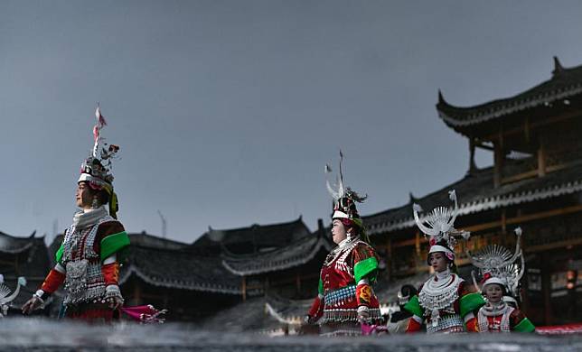 This inverted reflection shows girls of Miao ethnic group performing a dance in celebration of the Gannangxiang festival in Zhouxi Town of Kaili, Qiandongnan Miao and Dong Autonomous Prefecture, southwest China's Guizhou Province, Feb. 15, 2025. (Xinhua/Yang Wenbin)