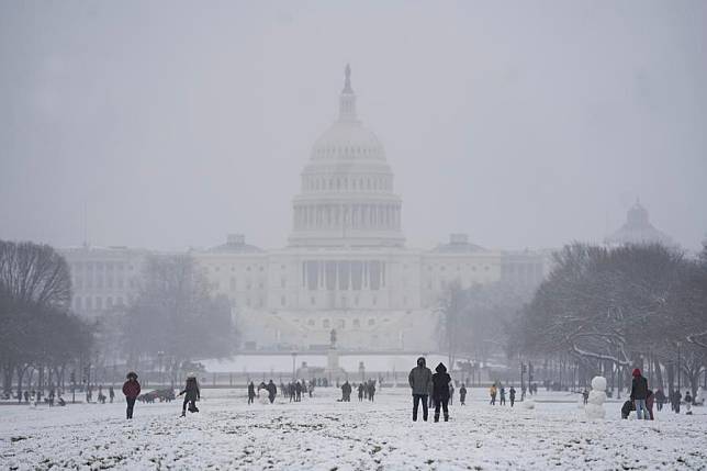 People play in the snow at the National Mall near the U.S. Capitol building in Washington D.C., the United States, Jan. 31, 2021. (Xinhua/Liu Jie)