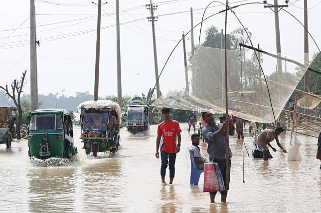 People wade through floodwater in Mymensingh, Bangladesh, Oct. 7, 2024. (Xinhua)