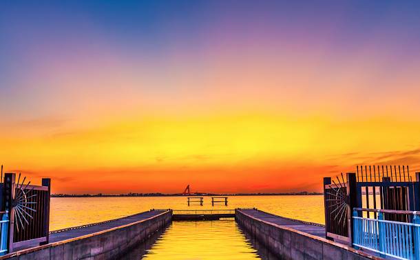  大鵬灣風景區內的落日灣，橘黃色的夕陽將海面染得一片橙黃，伴隨波光粼粼，頗富詩意。   圖：翻攝自大鵬灣國家風景區網站 