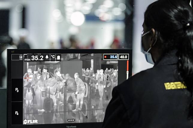 A Malaysian health official checks passengers going through a thermal scanner upon arrival at the Kuala Lumpur International Airport on January 21, 2020. Photo: EPA-EFE