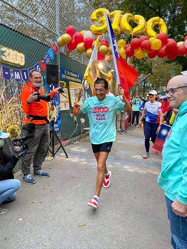 臺灣超馬好手羅維銘帶著笑容高舉國旗衝線，完成第25屆超越自我3100英里挑戰賽。（取自羅維銘臉書）