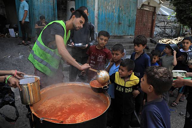 Palestinian children receive food relief in the southern Gaza Strip city of Rafah, on April 28, 2024. (Photo by Rizek Abdeljawad/Xinhua)