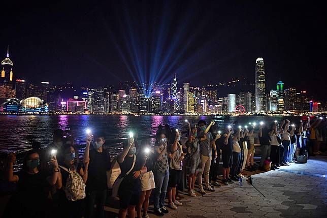 Protesters form a human chain along the Tsim Sha Tsui harbourfront in Hong Kong on Friday. Photo: AFP