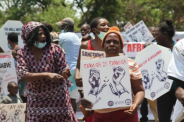 People hold placards during an anti-sanction protest in Harare, Zimbabwe, Oct. 25, 2021. (Xinhua/Tafara Mugwara)