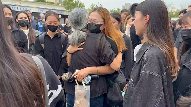 親友來送鄭詠心最後一程，在告別式會場外擁抱她的母親。（鏡新聞）