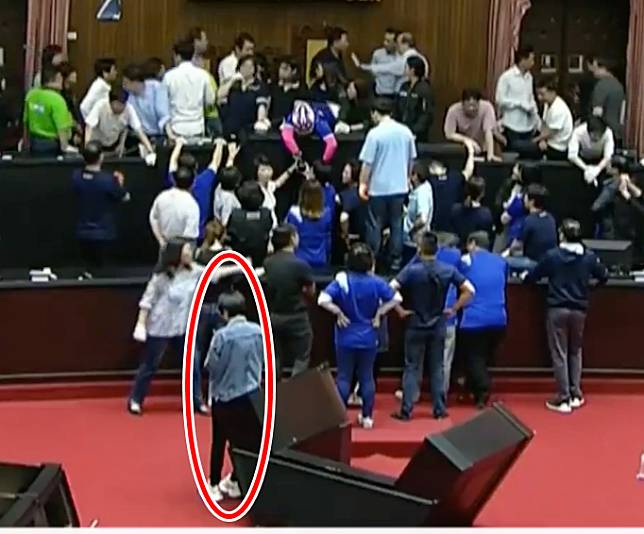 主席台上藍綠立委正在混戰，賴品妤在台下淡定PO文的身影被攝影機錄下。(圖擷自貓與邪佞的手指)