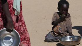 2025年11月22日，查德東部的臨時難民營，一名逃離蘇丹法舍的孤兒難民正在用餐。路透社