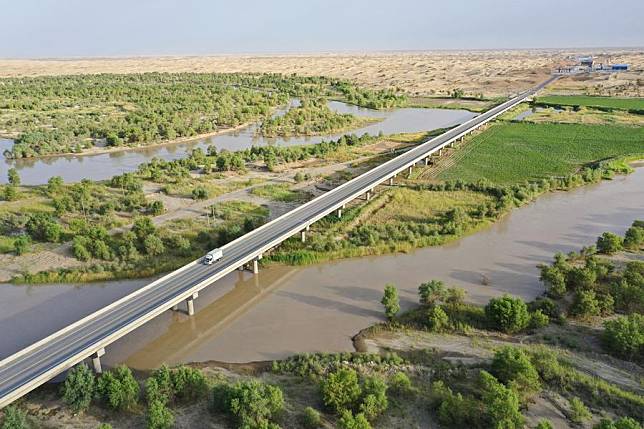 Aerial photo shows a section of a new desert highway traversing the Taklimakan Desert over the Tarim River in northwest China's Xinjiang Uygur Autonomous Region, June 22, 2022. (Xinhua/Li Xiang)