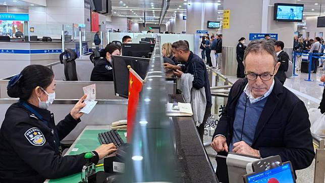 Border police officers check documents of travelers at a border checkpoint of the Shanghai Pudong International Airport in east China's Shanghai, March 14, 2024. (Photo by Wei Wenheng/Xinhua)