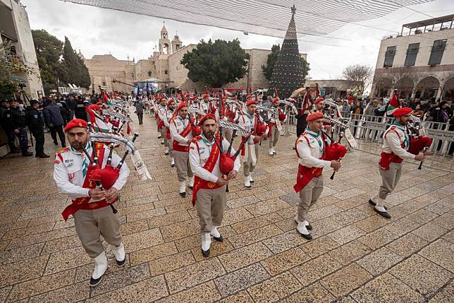 Palestinians perform outside the Church of the Nativity, revered as the site of Jesus Christ's birth, during Christmas celebrations in the West Bank city of Bethlehem, Dec. 24, 2021. (Photo by Luay Sababa/Xinhua)