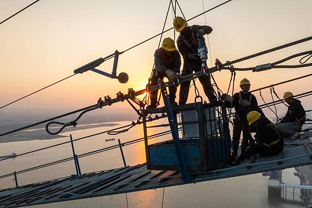 An aerial drone photo taken on Dec. 16, 2024 shows builders working on the construction site of Yanji Yangtze River Bridge in central China's Hubei Province. (Xinhua/Xiao Yijiu)