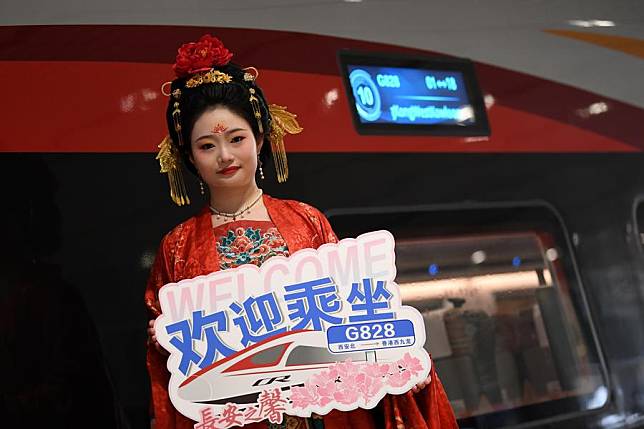 A staff member, dressed in traditional costume, greets passengers of the train G828 bound for Hong Kong, at Xi'an North Railway Station in Xi'an, northwest China's Shaanxi Province, Jan. 5, 2025. (Xinhua/Li Yibo)