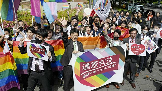 日本名古屋的地方法院外，地院判決不承認同性婚姻違憲後，包括原告律師在內的民眾舉著橫幅和旗幟慶祝。路透社