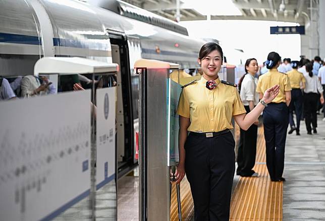 A staff member welcomes passengers for intercity railway at Machong Station in Dongguan, south China's Guangdong Province, May 26, 2024. (Xinhua/Liu Dawei)