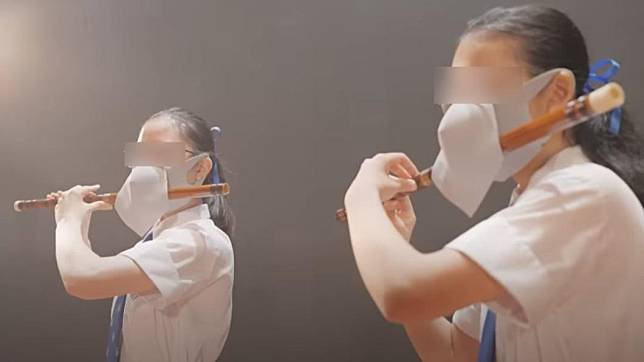 影片中學生戴口罩吹笛子的畫面引發熱議。（圖／翻攝自香港教育局 YouTube）